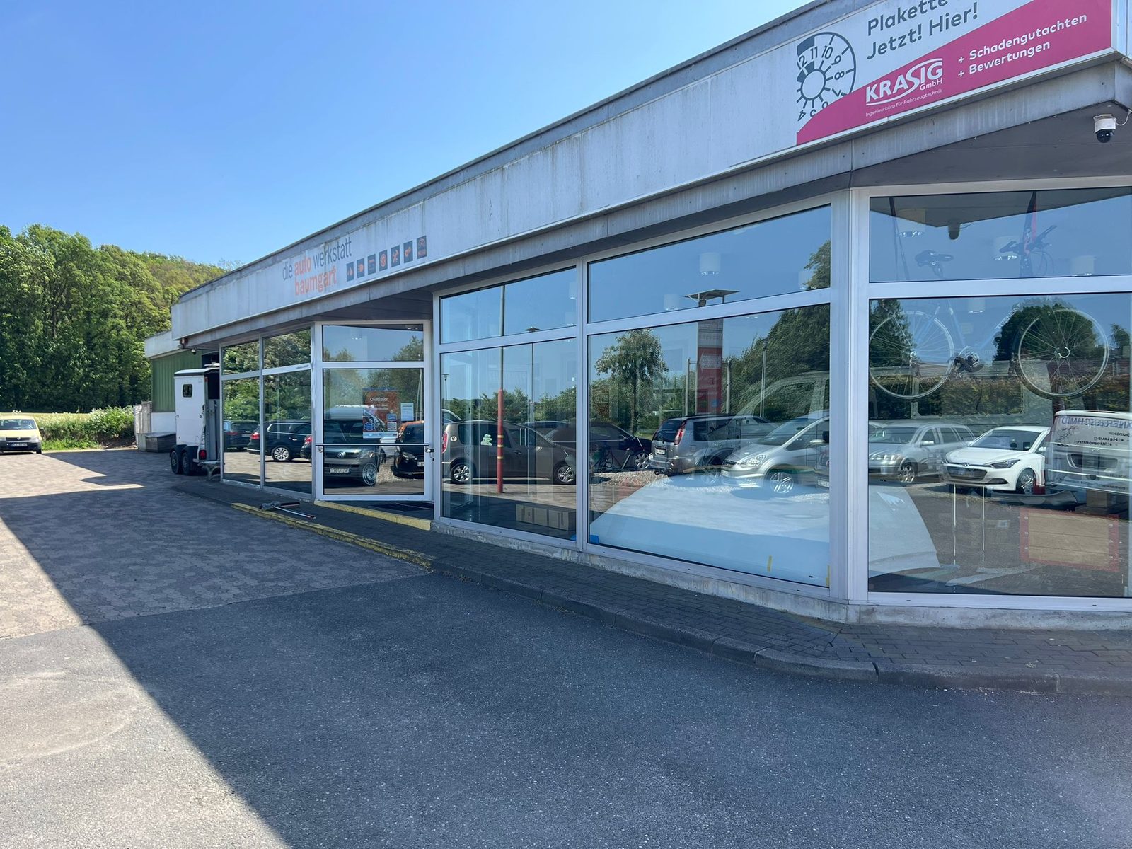 Spiegelblank gereinigte Glasfront und Schaufenster eines Autohauses durch reinKraft — streifenfreies Ergebnis bei Sonnenlicht